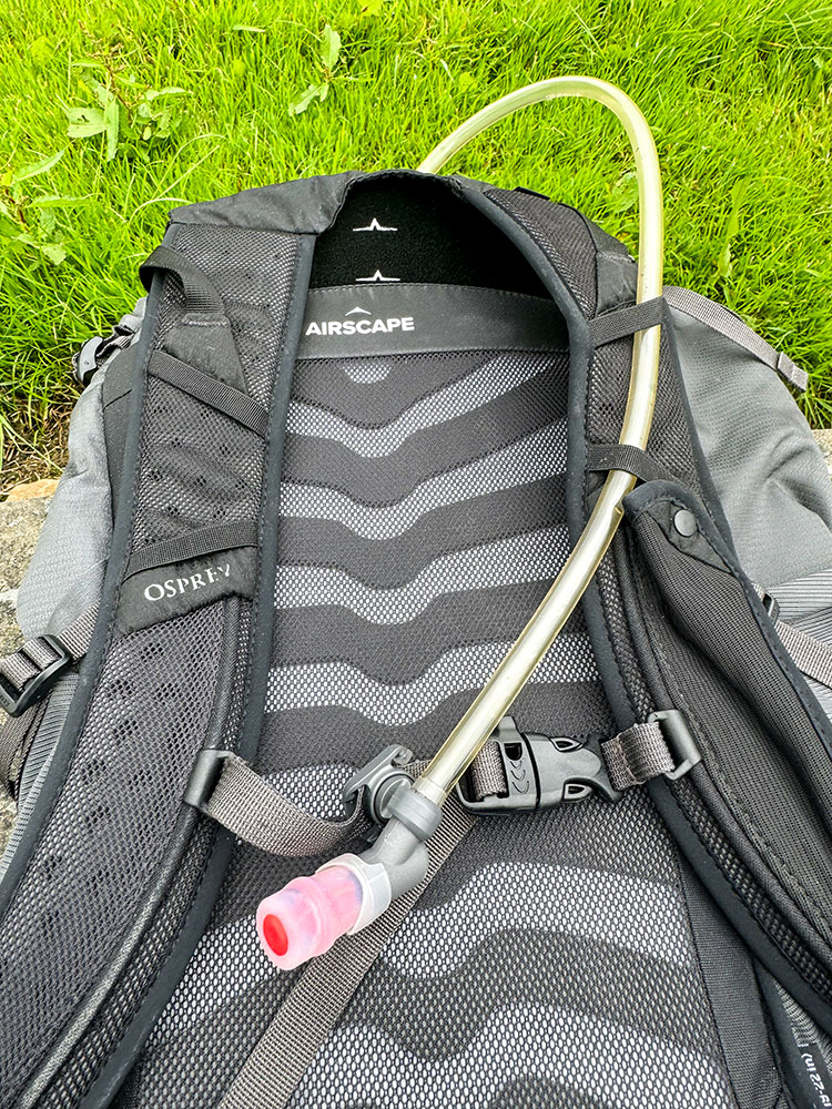 Hydration tube fed through loops on shoulder strap on backpack