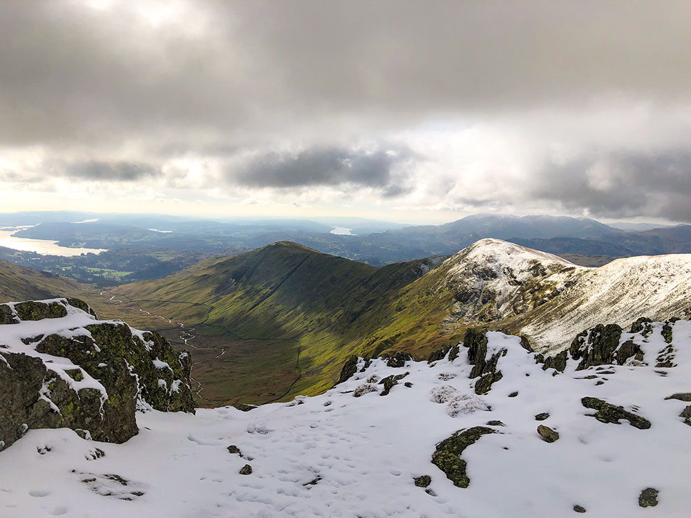 Looking back down towards Windermere from a snow-capped Fairfield Horseshoe in the Lake District