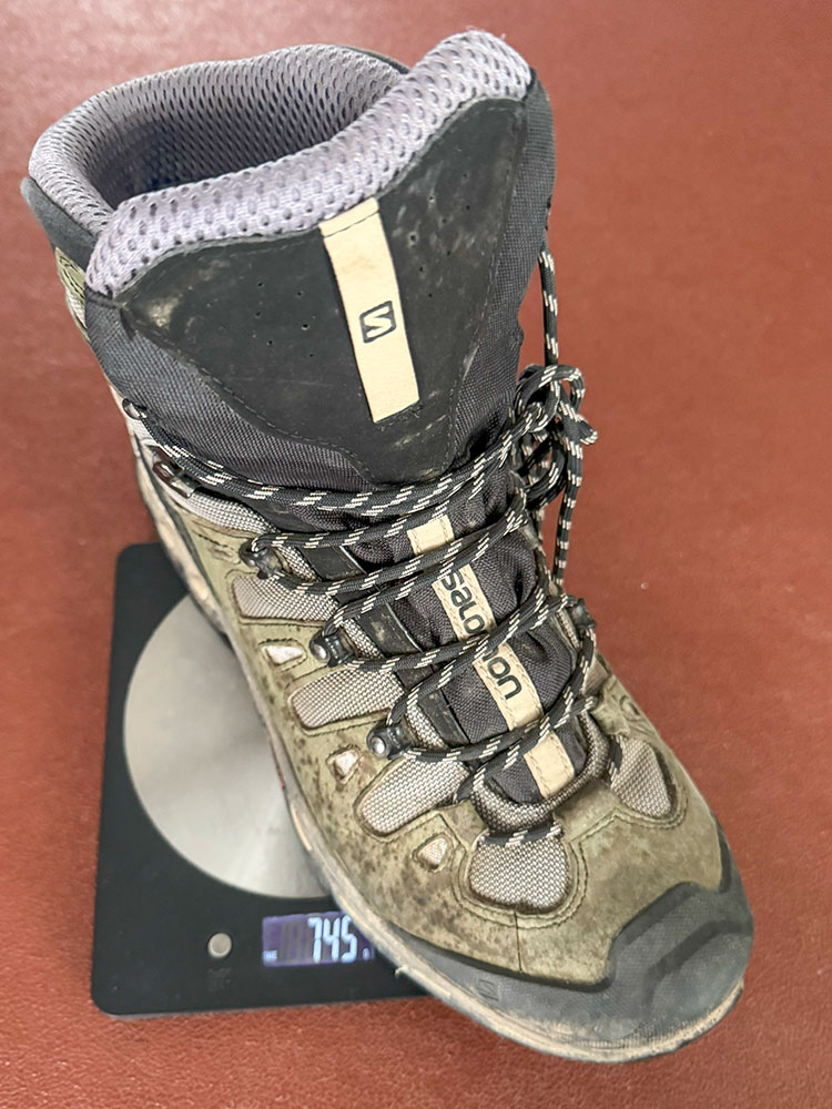 A midweight hiking boot on a scale, weighing 1.5Kg for the pair