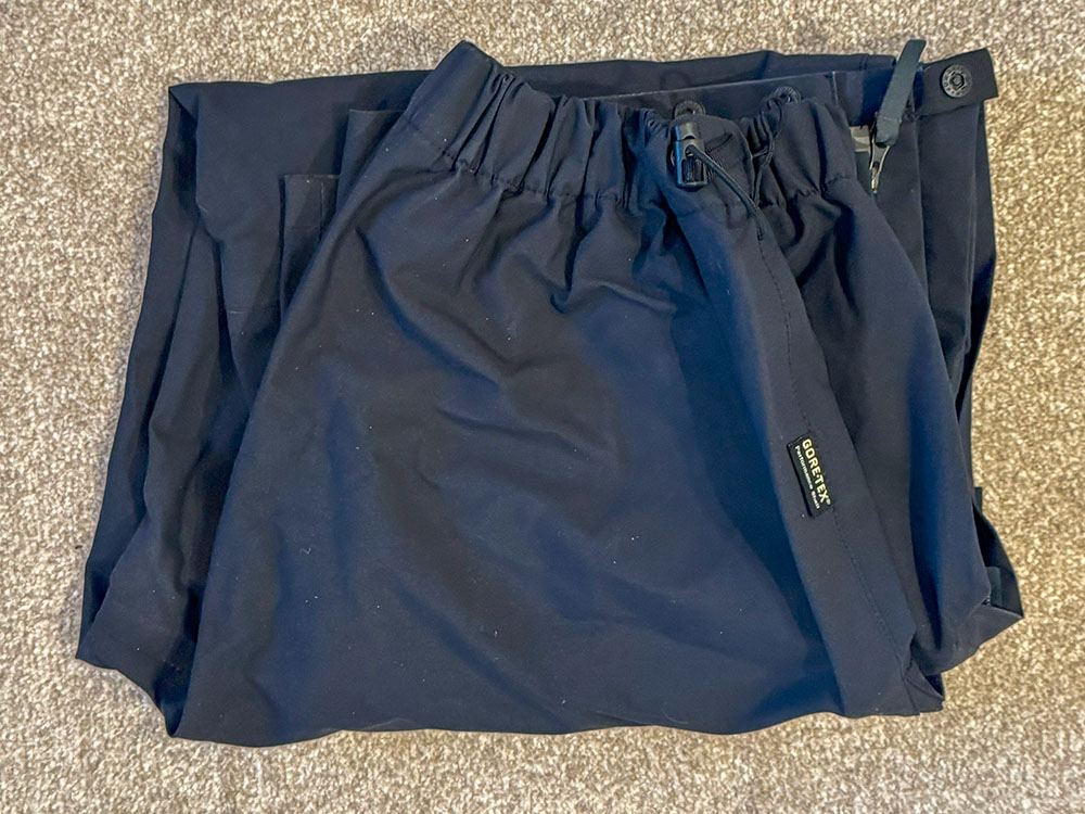 Waterproof trousers folded in half again to create a compact rectangle