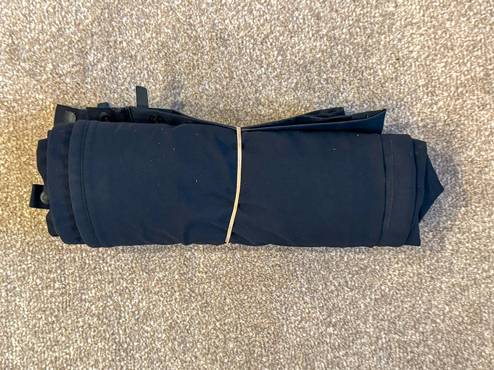 The waterproof trousers rolled with a band around them