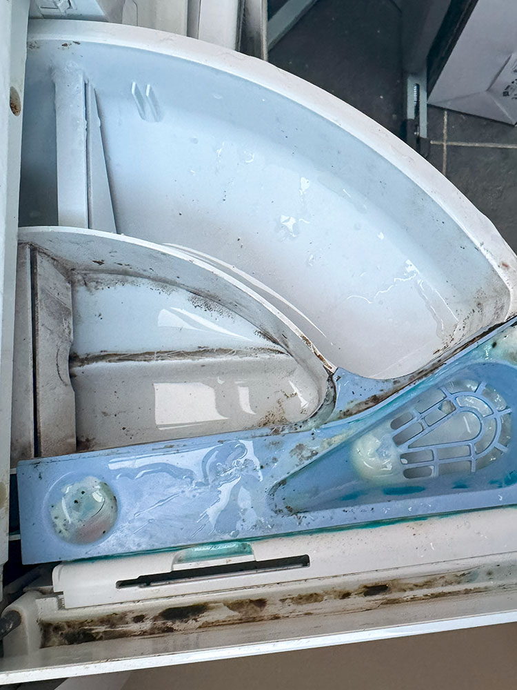 Washing machine drawer before cleaning out all previous remaining detergent and conditioner