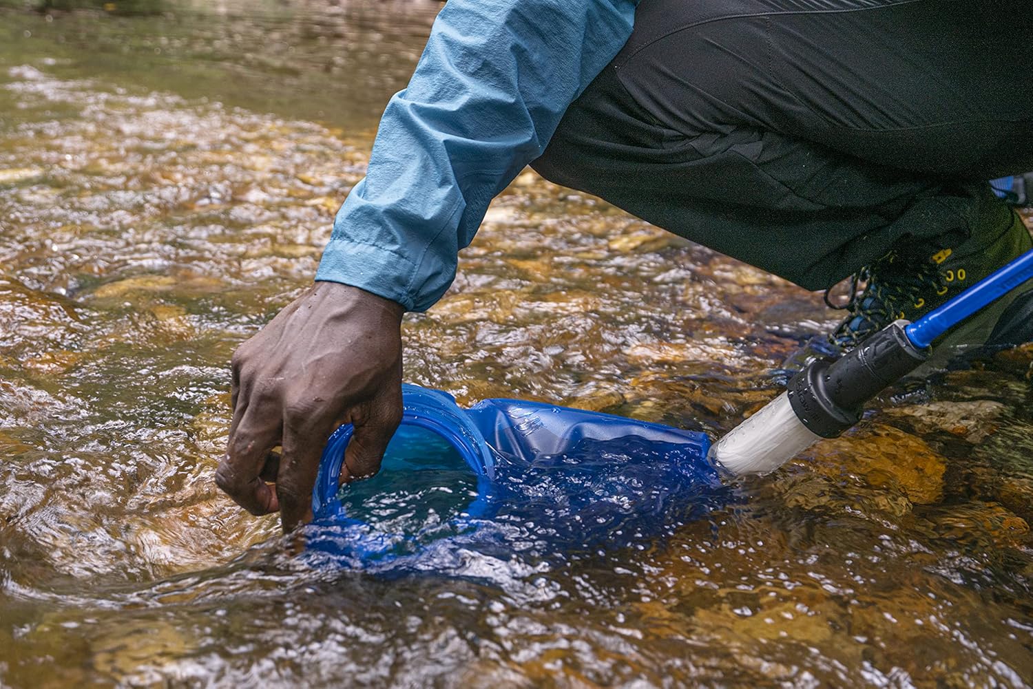 Filling up the CamelBak Crux Reservoir filtered by LifeStraw in a stream