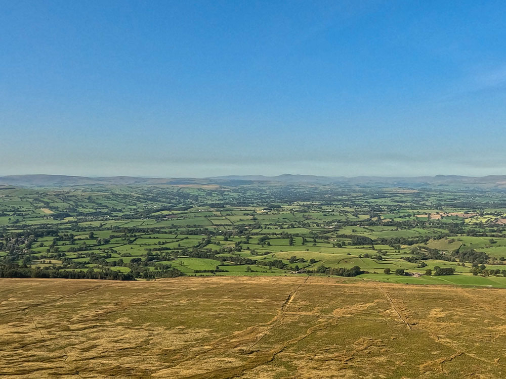 Over to the right, Downham can be seen over Hookcliffe Plantation, with Ingleborough, Pen-y-ghent, and Fountains Fell as visible on the horizon