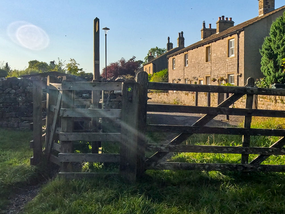 Pass through the kissing gate and keep straight ahead along the road