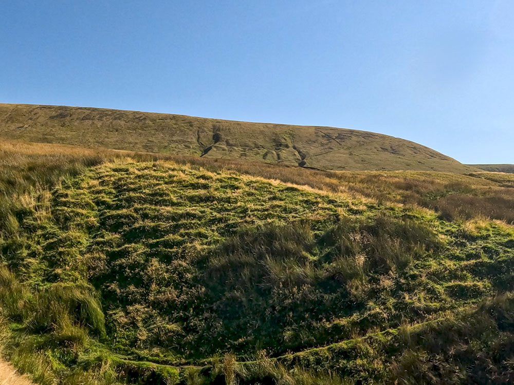 The path briefly dips down to pass over a small stream