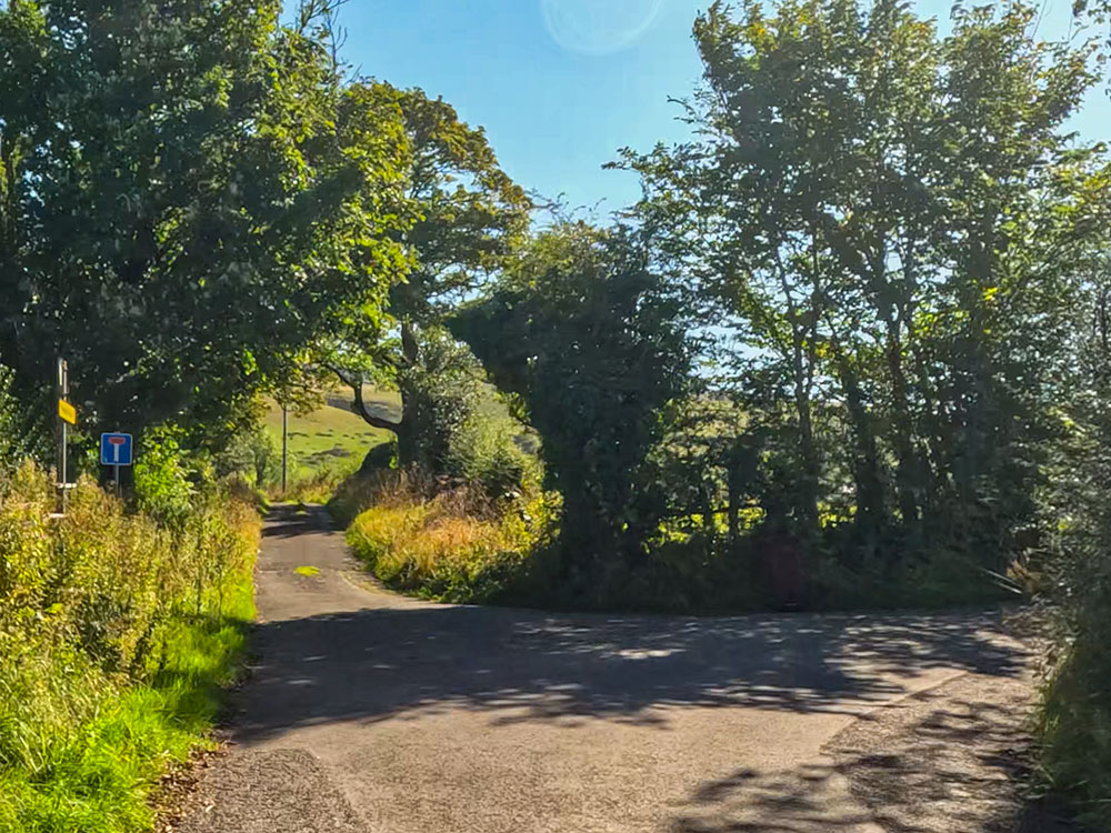 As the road bends around to the right, the route follows the lane straight on up the cul-de-sac