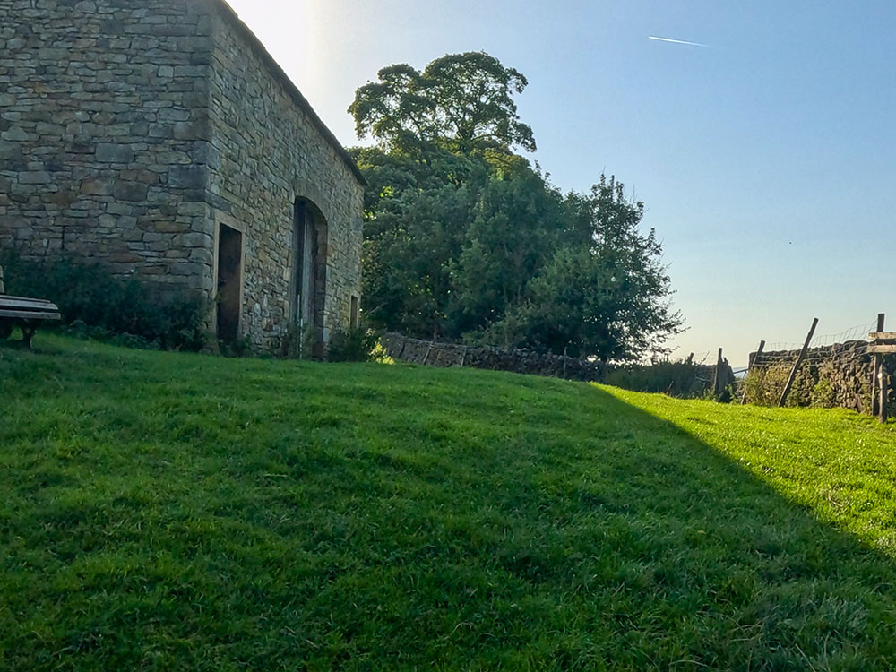 Head towards the stile opposite the building and bench