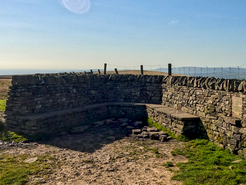 The weather shelter seats built into the wall on Pendle Hill