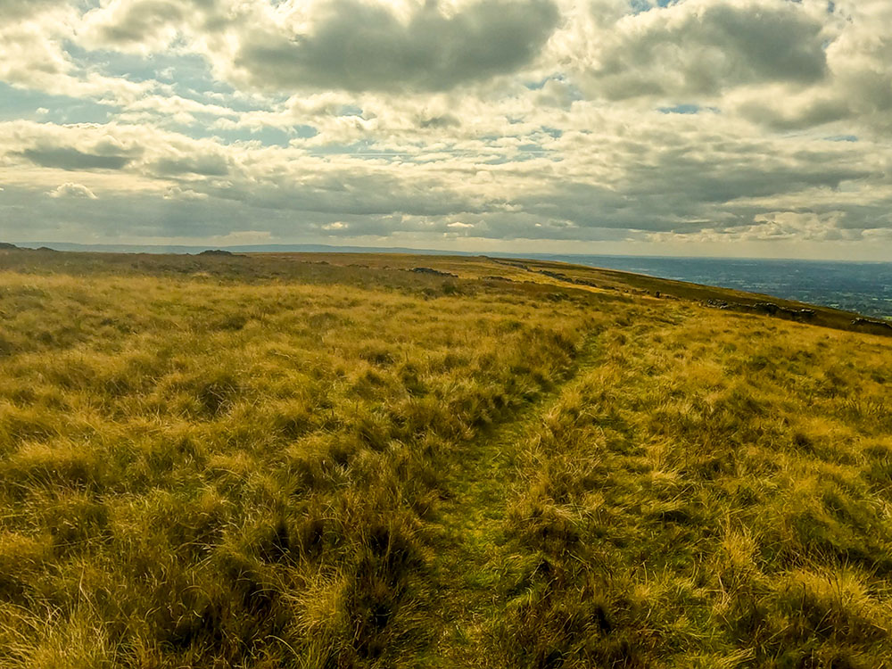 Heading along the path over Pendle Moor towards the two tumbled-down walls ahead