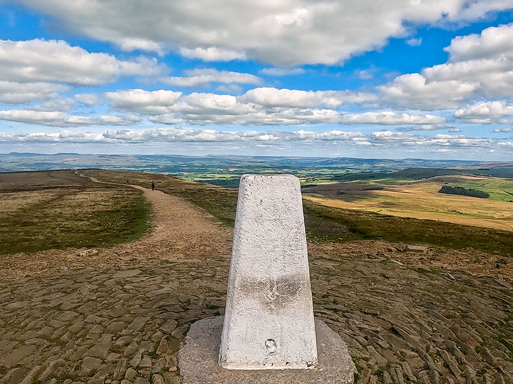 Looking over the trig point on the summit of Pendle Hill towards the Yorkshire Three Peaks (Ingleborough, Whernside and Pen-y-ghent)