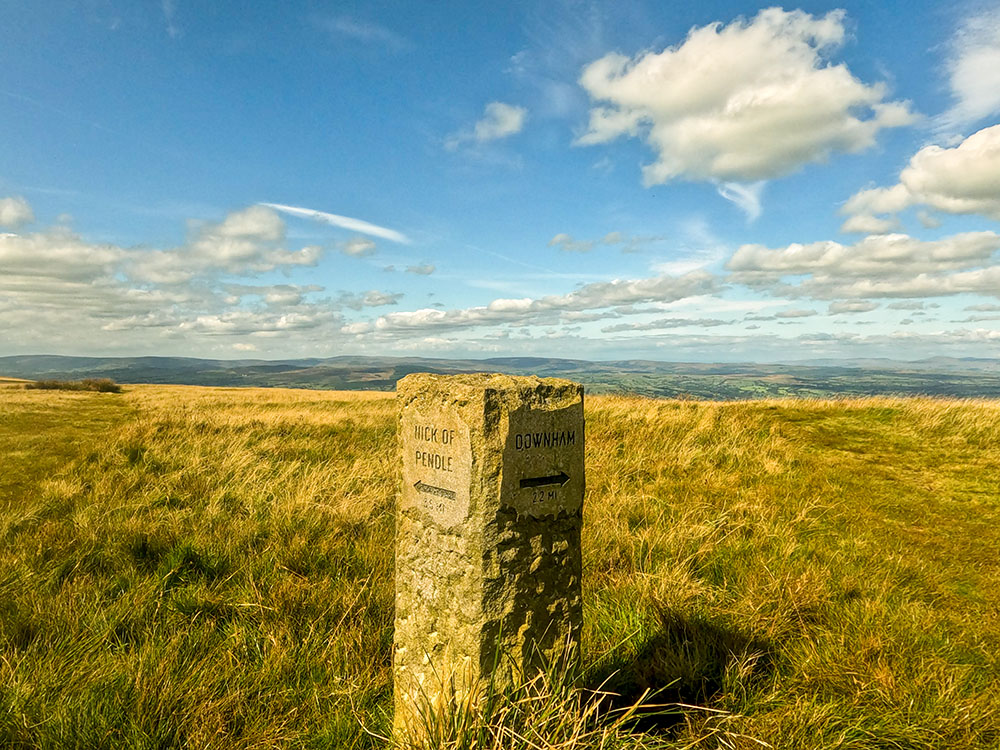 The stone marker just through the gate, showing Nick of Pendle to the left and Downham straight on