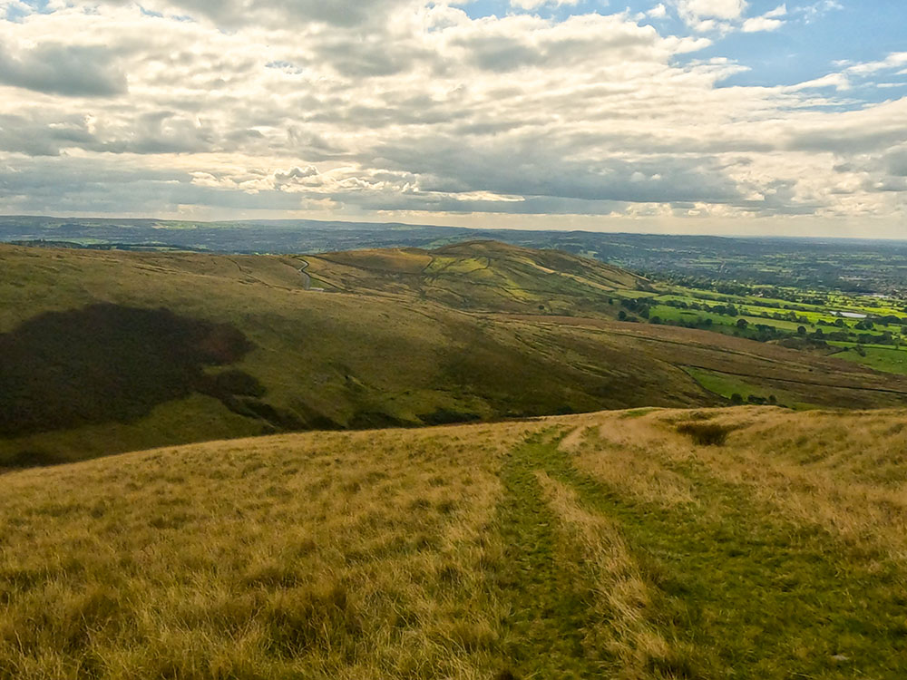 Follow the wide grassy path as it descends more steeply off Mearley Moor