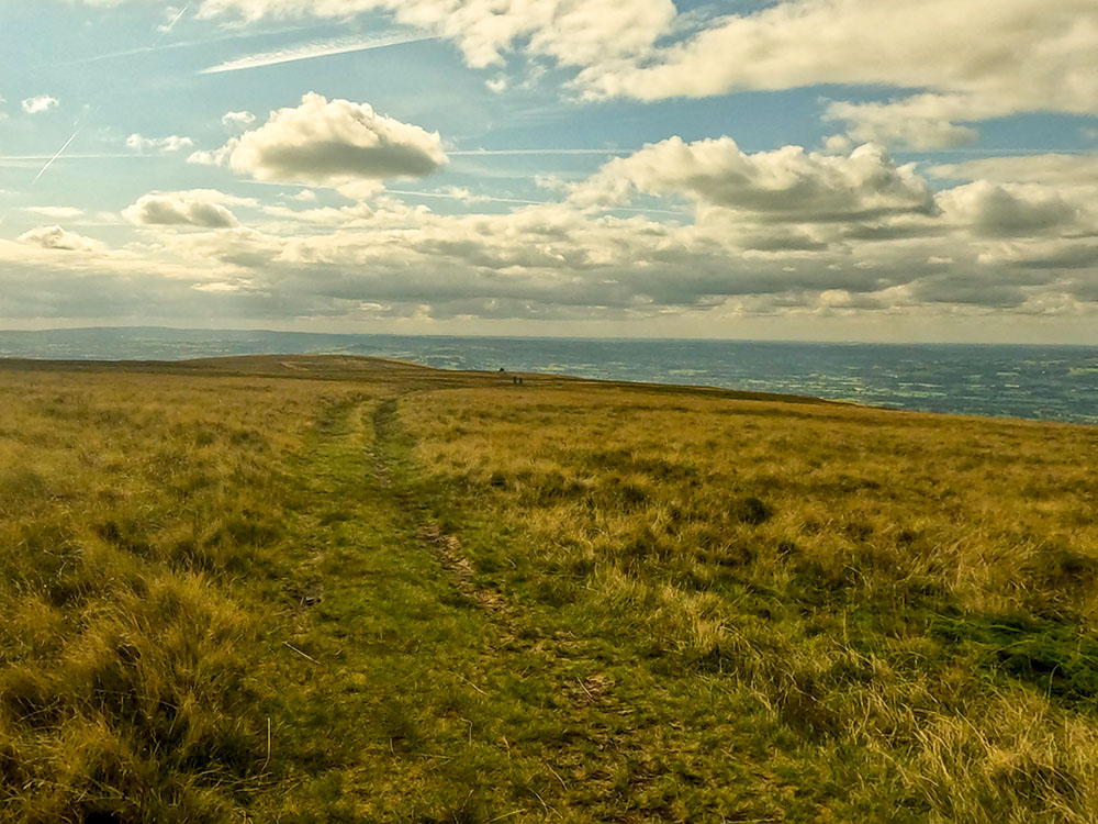 The wide grassy path heading from the weather shelter towards the Scout Cairn (marked as a pile of stones on the OS map)