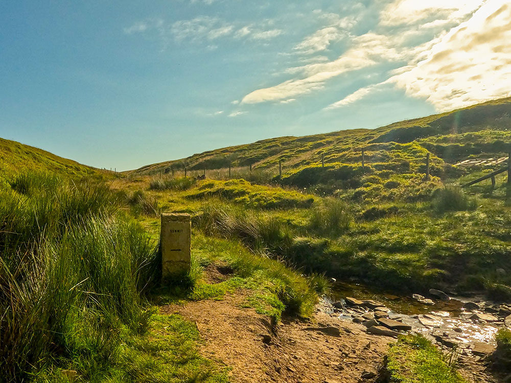 The stone marker pointing over the stream through Ogden Clough and to the summit of Pendle Hill